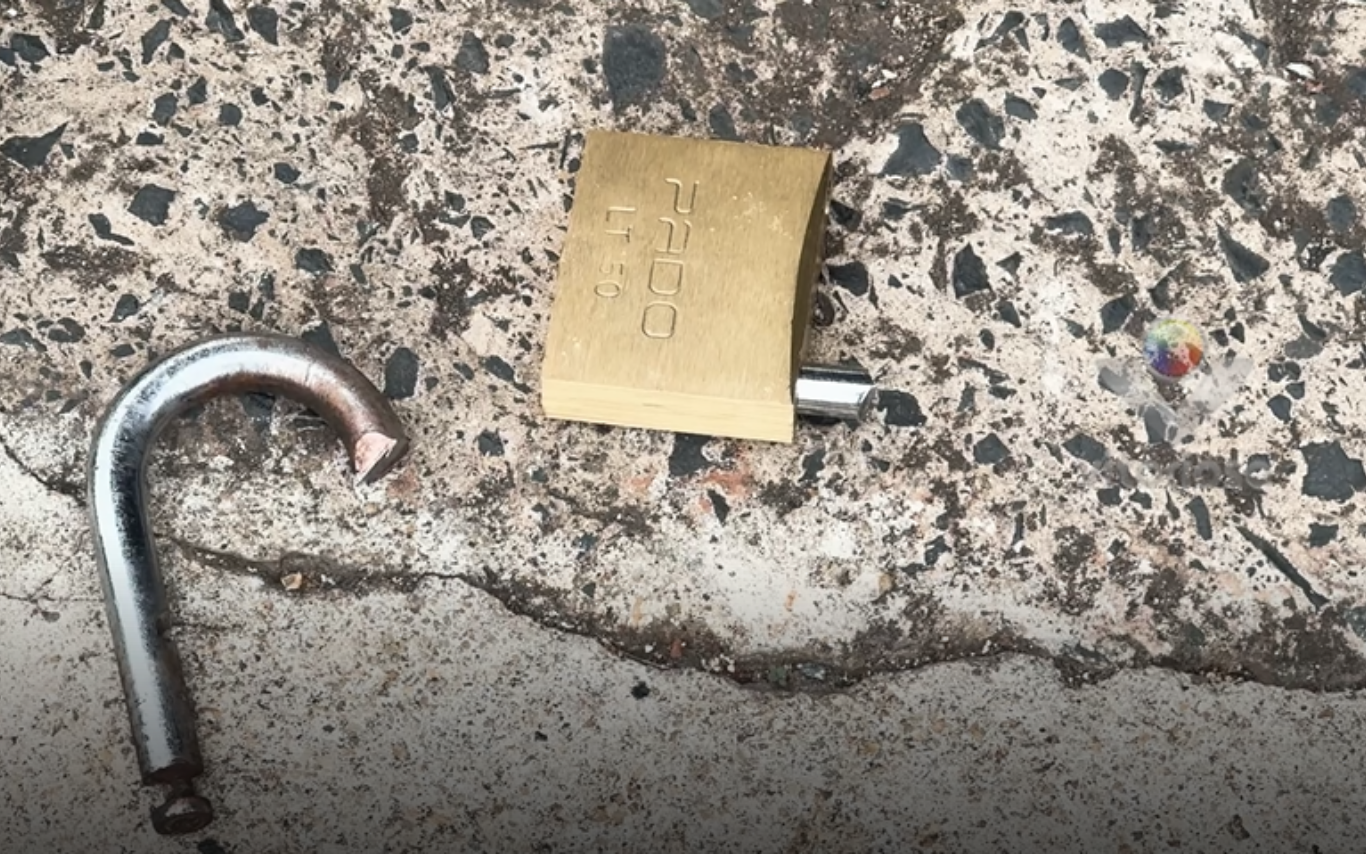 Cadeado quebrado pelos criminosos que furtaram loja de veículos.