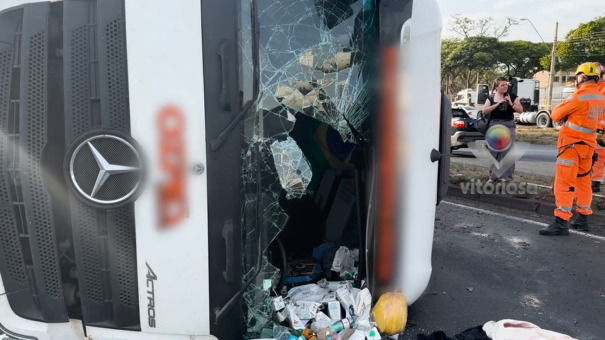Imagem da carreta caída em meio à rodovia.